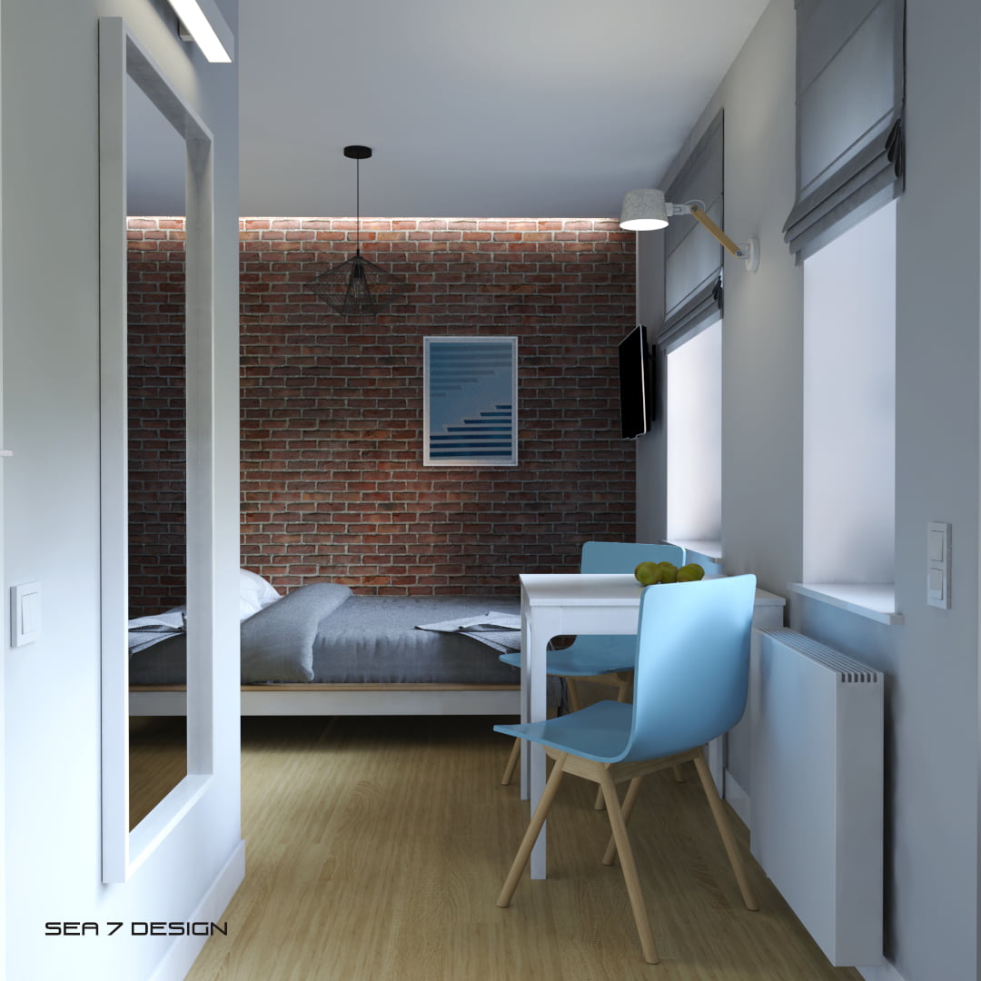 Sea 7 Design, Sopot apartment for rent blue mist bedroom, view on a white table with blue chairs and a double bed, a big mirror and a red brick wall.