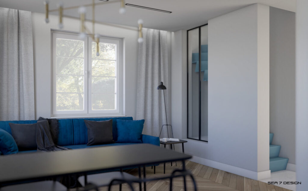 Sea 7 Design, Blue Minima Apartment, living room, view on a blue velvet sofa, a black coffee table with a cup and an open book, and modern black floor lamp. There are blue stairs on the right.